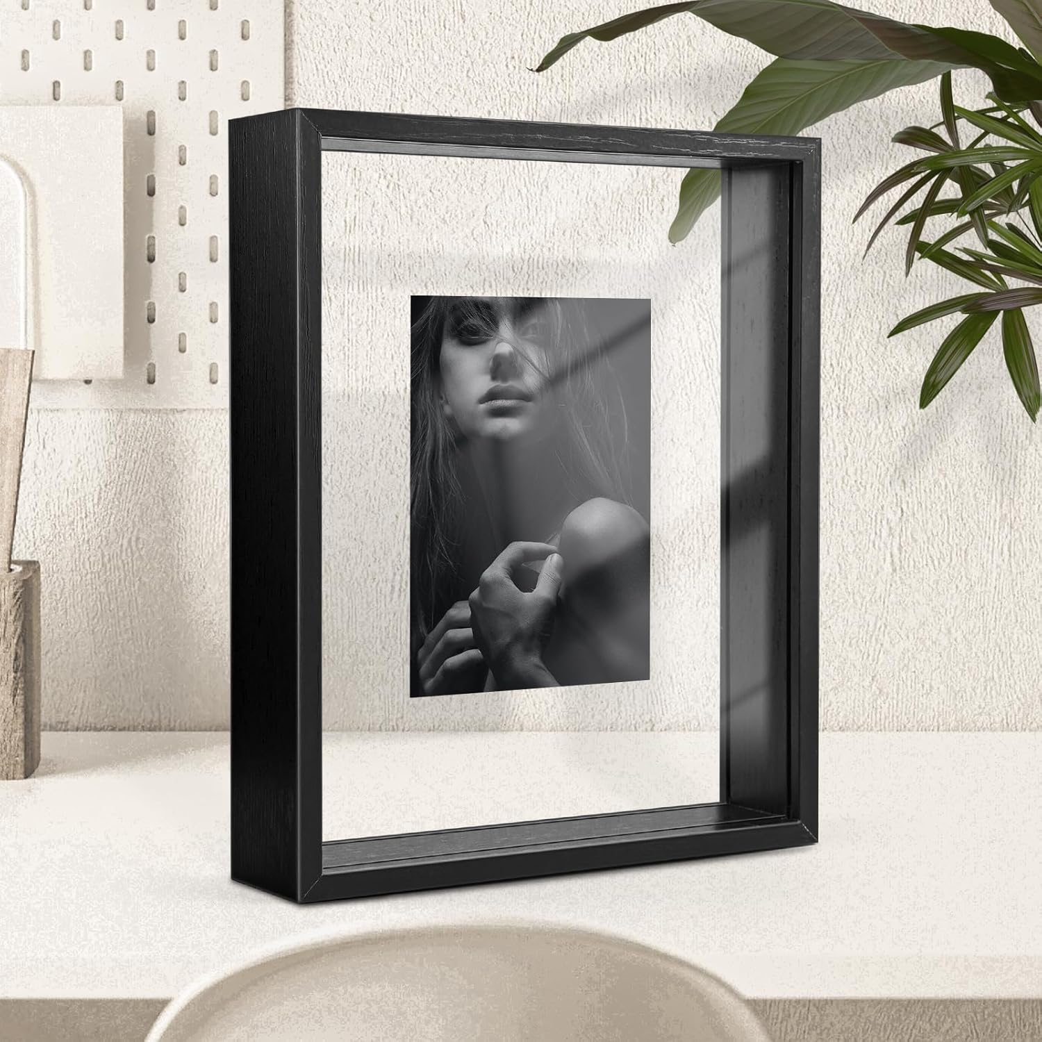 Marco de fotos flotante de 20 x 25 cm, compatible con fotos de 15 x 20, 13 x 18, 10 x 15 cm y más pequeñas. Fabricado en MDF y plexiglás, incluye cinta adhesiva de doble cara. Diseño robusto ideal para uso en mesa o pared.